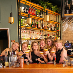 groep-poseert-met-cocktails-achter-de-bar-bij-bpm-bar-eixample-in-barcelona